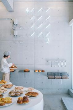 a man standing in front of a counter filled with donuts and other pastries