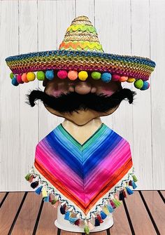 a man with a mustache wearing a colorful mexican sombrero on top of his head