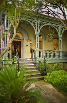 an old house with many windows and balconies on the front porch, surrounded by greenery