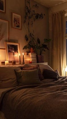 a bed sitting next to a window with candles on top of it in front of a lamp