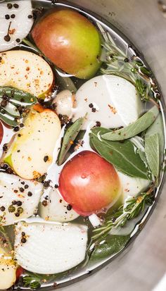 apples, onions and herbs are in a pot with water on the stove burner