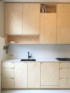 an empty kitchen with wooden cabinets and white counter tops, including a stove top oven