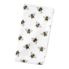 a white and yellow bee print pocket square on top of a white napkin with black bees all over it