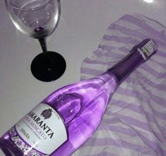 a bottle of vodka next to a wine glass on a table with a striped towel