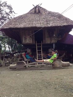 two people sitting on chairs in front of a hut