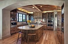 a large kitchen with wooden floors and an arched doorway