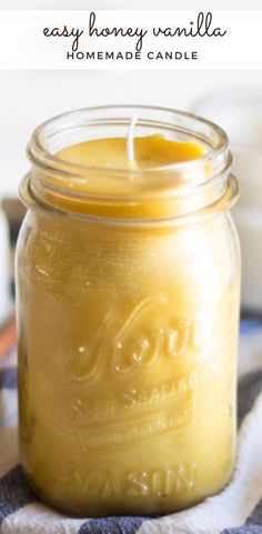 a mason jar filled with homemade beeswap candle sitting on top of a blue and white checkered cloth