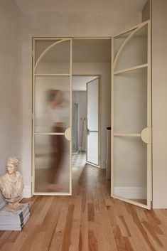 an open door leading to a hallway with a statue on the floor next to it