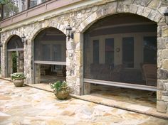 an outdoor patio with stone walls and furniture