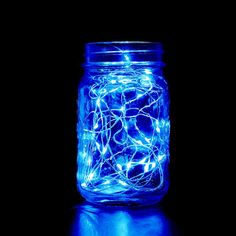 a jar filled with blue lights on top of a table