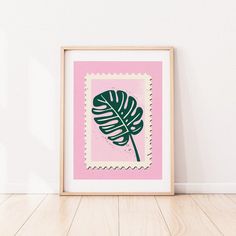 a pink and green print with a large leaf on the front, against a white wall