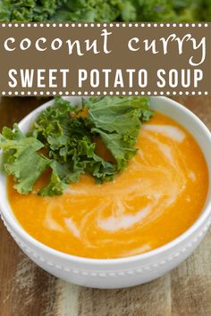 a white bowl filled with carrot soup on top of a wooden table