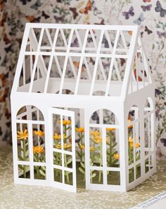 a paper model of a house with flowers inside