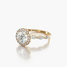 an engagement ring with a diamond center and side stones on the band, set in 18k rose gold