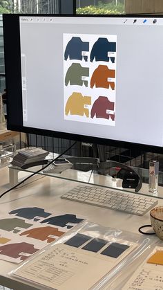 a computer monitor sitting on top of a desk next to a bowl and cup filled with liquid