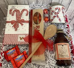 an assortment of candy and treats in a gift box with a bottle of booze