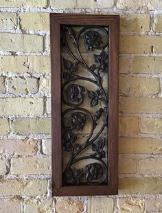 a decorative metal piece mounted to the side of a brick wall