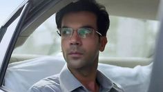 a man wearing glasses sitting in the passenger seat of a car