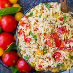 a bowl filled with rice and tomatoes next to some other vegetables on a table top