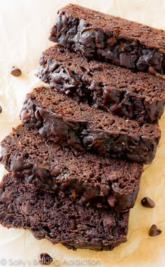 three slices of chocolate cake sitting on top of each other next to some coffee beans