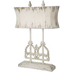 a lamp that is sitting on top of a wooden stand with a white shade over it