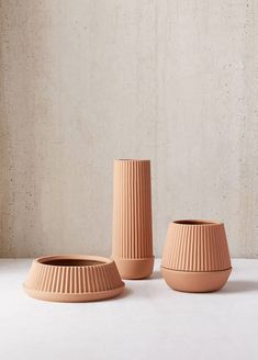 three clay vases sitting next to each other on a table