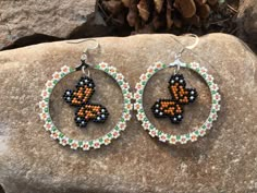 a pair of beaded hoop earrings on top of a rock