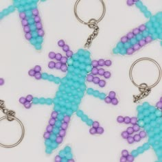 several key chains with blue and purple beads in the shape of a geckoe