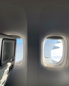 the view from inside an airplane looking out the window at the wing and television screen