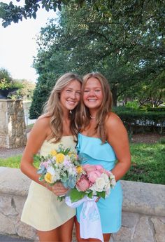 two young women standing next to each other holding bouquets