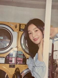 a woman standing in front of a washing machine