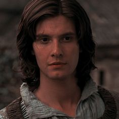 a young man with long hair wearing a sweater