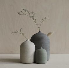 three vases with flowers in them sitting on a table