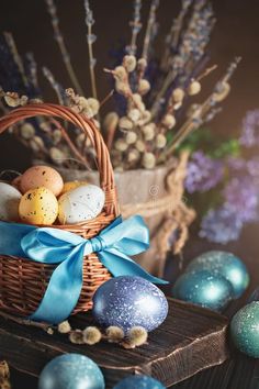 an easter basket with painted eggs and flowers in the background royalty images, stock photos