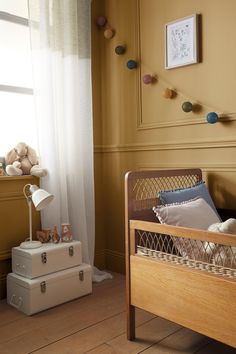 a small child's bed in the corner of a room with two suitcases