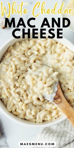 white cheddar mac and cheese in a bowl with a wooden spoon on the side