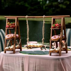 two wooden swings with donuts and strawberries on them are set up for a wedding reception