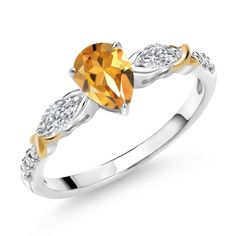 a yellow diamond ring with two white diamonds on the band and an oval cut stone in the center