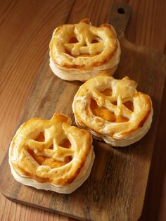 three small pies sitting on top of a wooden cutting board