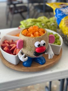 a bowl filled with carrots sitting on top of a wooden tray next to bowls of vegetables