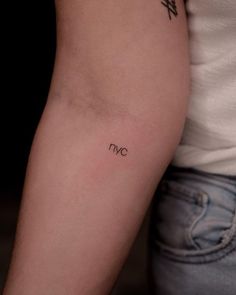 a woman's arm with a tattoo on it that reads nyc and has the letter n in cursive writing