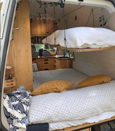 the interior of a camper van with bunk beds and pillows on it's sides