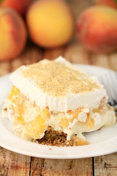 a piece of cake sitting on top of a white plate next to some peaches