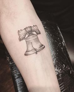 a tattoo with a bell on the arm