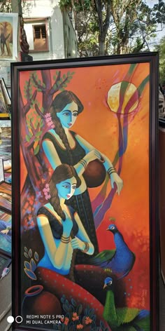 a painting on the side of a building with two women sitting next to each other