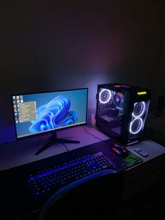 two computer monitors sitting next to each other on top of a desk in the dark