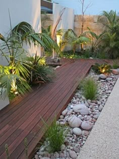 a wooden deck surrounded by plants and rocks