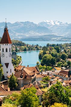 an aerial view of a town with a lake and mountains in the background