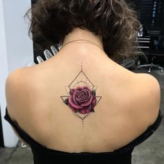 the back of a woman's neck with a rose tattoo on it