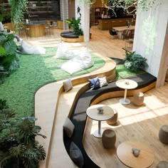 a living room filled with lots of furniture and plants on top of wooden flooring